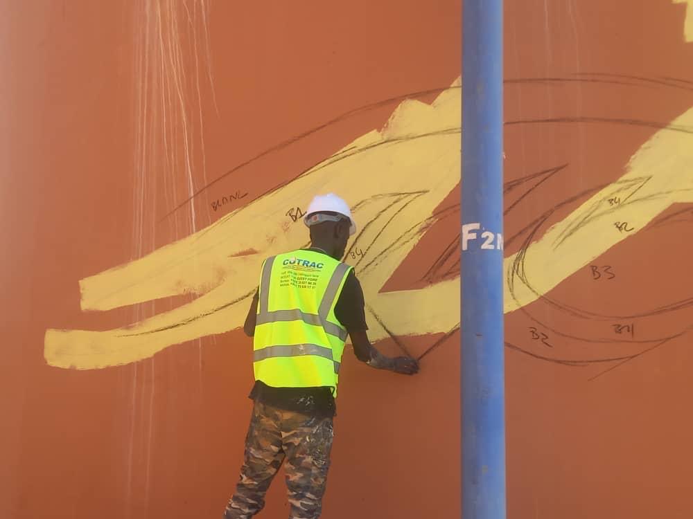 Technicien COTRAC appliquant la peinture de préparation sur le château d'eau SEN'EAU à Thiès