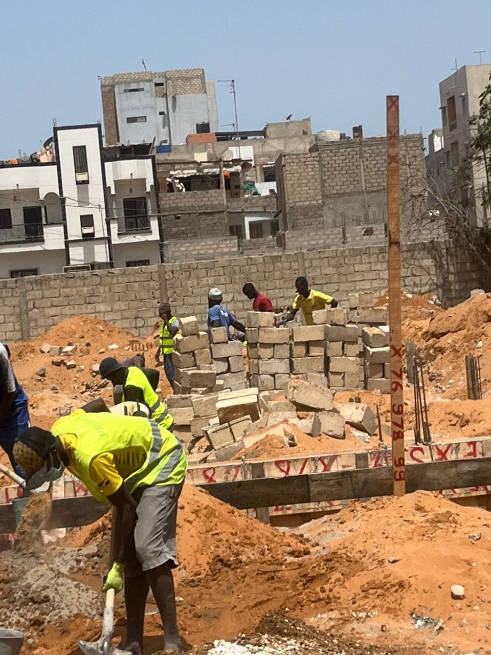 Maçons COTRAC montant les murs en agglos